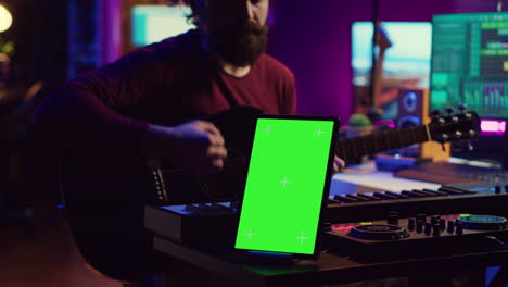 compositor tocando la guitarra acústica en su estudio de casa