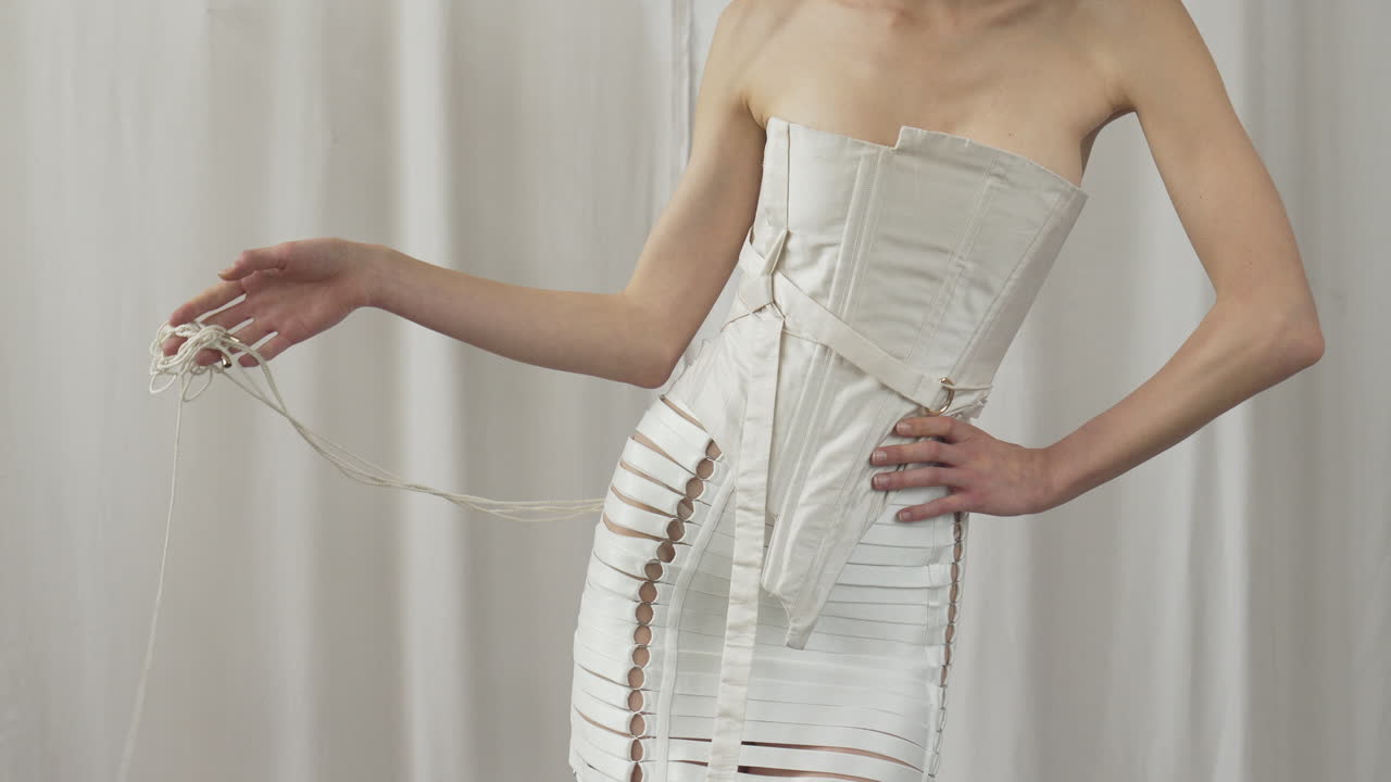 패션 편집을 위해 스타일링 된  ⁇ 색 코르 ⁇ ,  ⁇ 색 배경에 대한 사진 촬영을 위해 포즈를 취하는  ⁇ 은 여성 모델