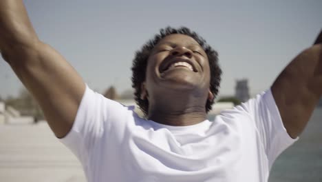 smiling young sportsman finishing running training