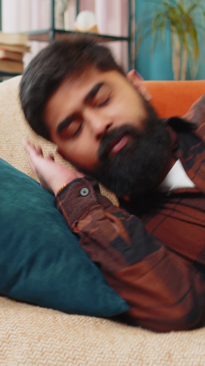 joven indio cansado acostado en la cama tomando un descanso en casa durmiendo durmiendo en el sofá