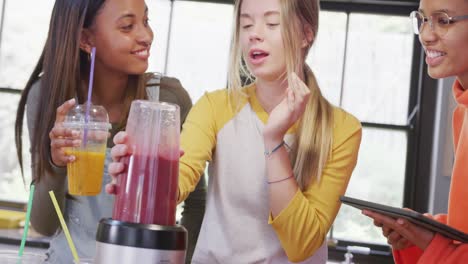 Felices-Y-Diversas-Amigas-Adolescentes-Preparando-Bebidas-Saludables-Usando-Tabletas-En-La-Cocina,-Cámara-Lenta