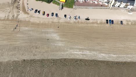 Duncannon-Beach-with-cars-parked-and-people-walking-with-the-tide-out-wexford-Ireland