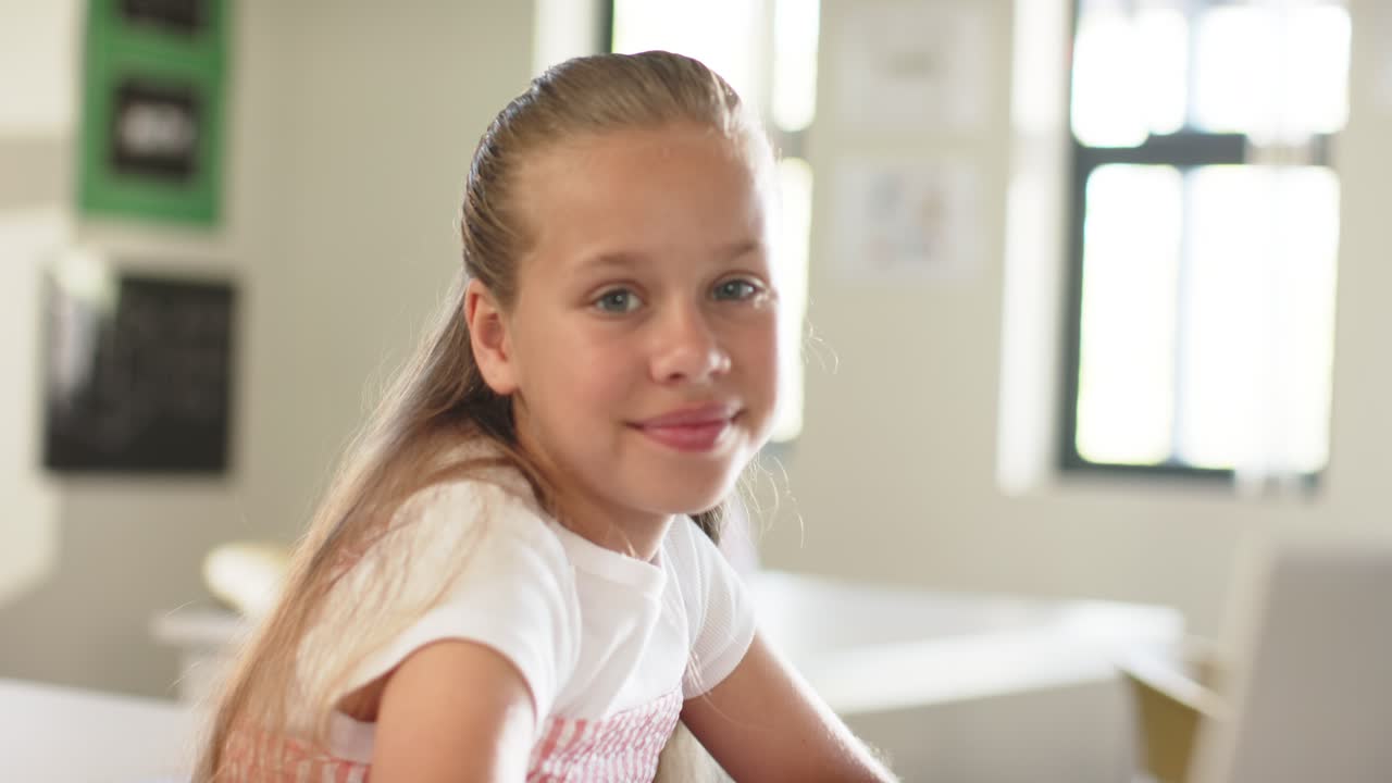 Girl student smiling, moving while frame tightening sitting at school desk with laptop and windows