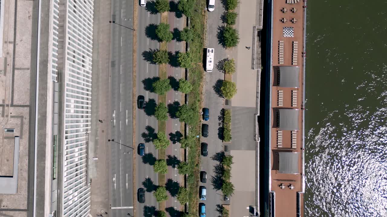 Cologne, North Rhine-Westphalia, Germany - Aerial bird drone flight of the Konrad-Adenauer-Ufer street along the Rhine - Flyover vertical shot of a big street with traffic - trees and bike lane