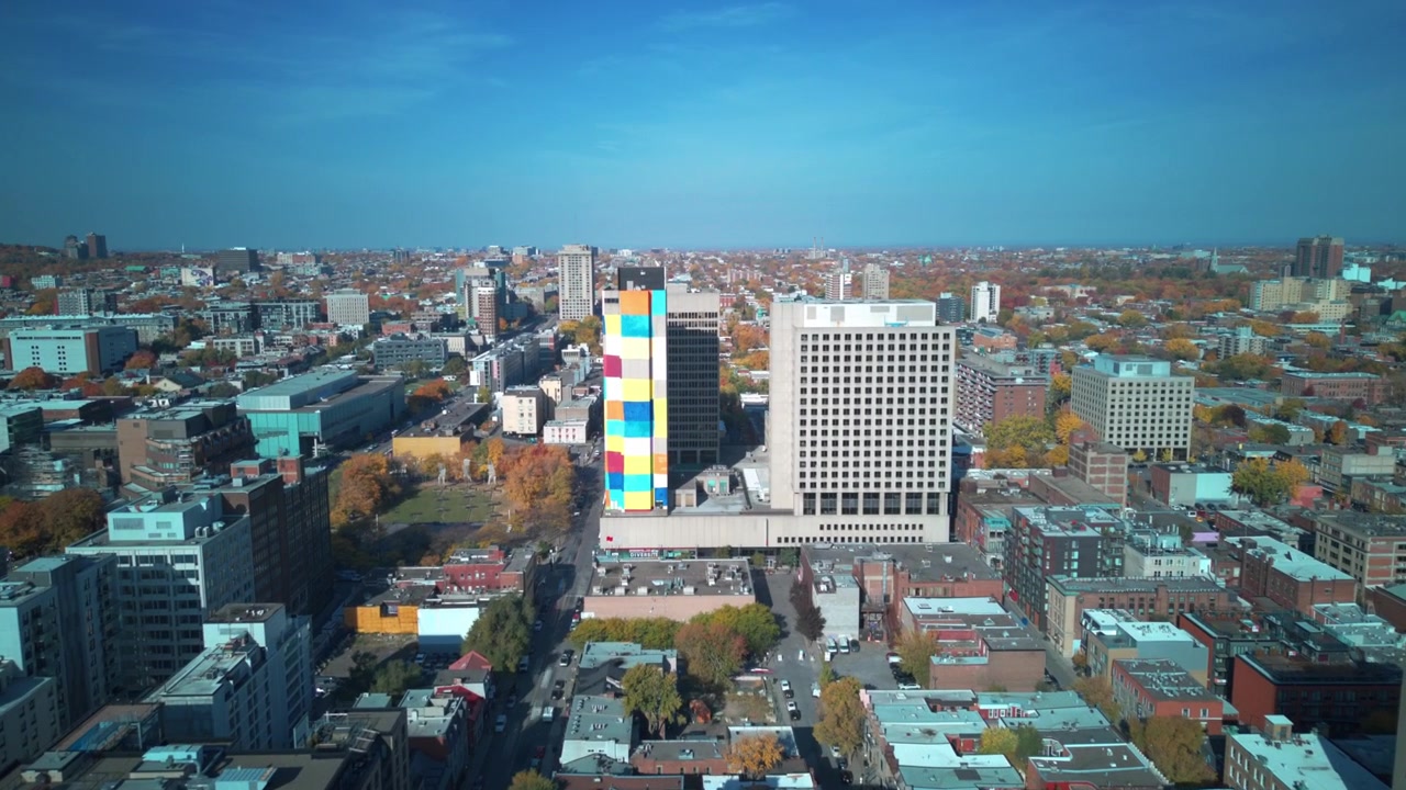 Una ripresa aerea in hyperlapse con drone verso un edificio colorato nella città di Montreal durante l'estate.