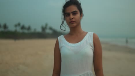 Young-woman-in-white-on-a-hazy-beach-during-early-morning,-out-of-focus-and-dreamy-atmosphere