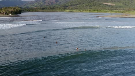 surfistas atrapando olas en la costa del pacífico al atardecer, vista aérea