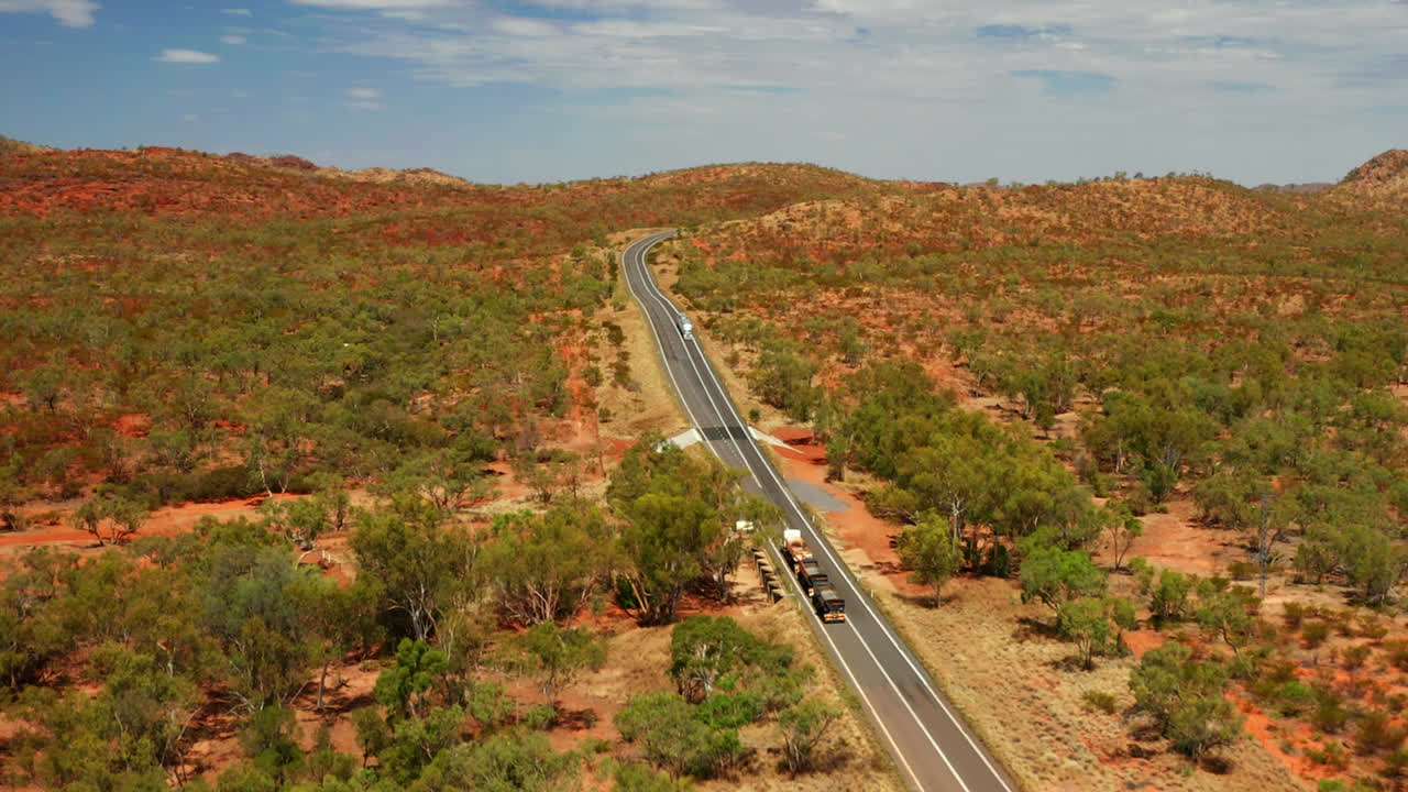 vehículos que circulan por carreteras rurales entre la vegetación en queensland, australia - toma aérea de drones