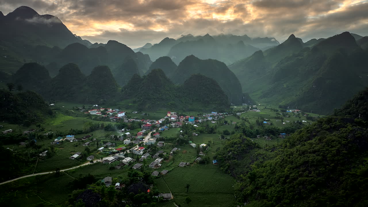 Lung Ho village surrounded by dramatic karst mountains. Sunset aerial hyperlapse
