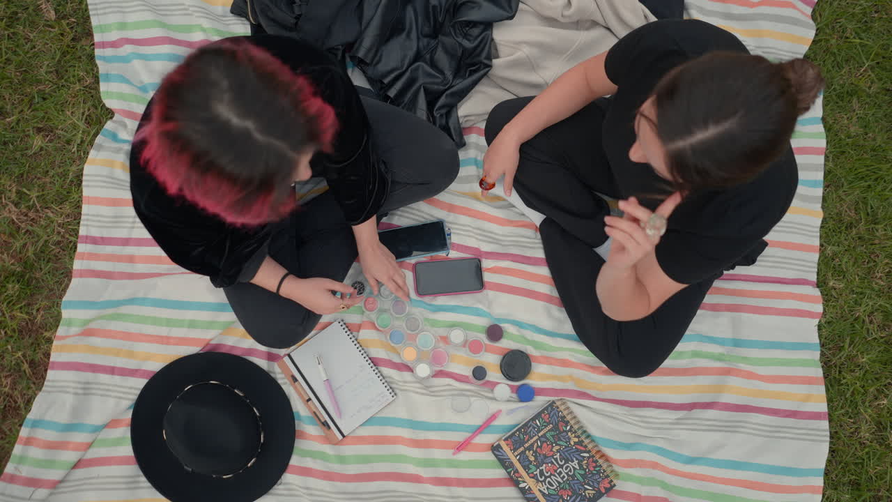 Friends collaborating on makeup outdoors