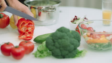 Nahaufnahme-Eines-Mannes,-Der-Rote-Paprika-Mit-Einem-Scharfen-Messer-In-Zeitlupe-Schneidet.