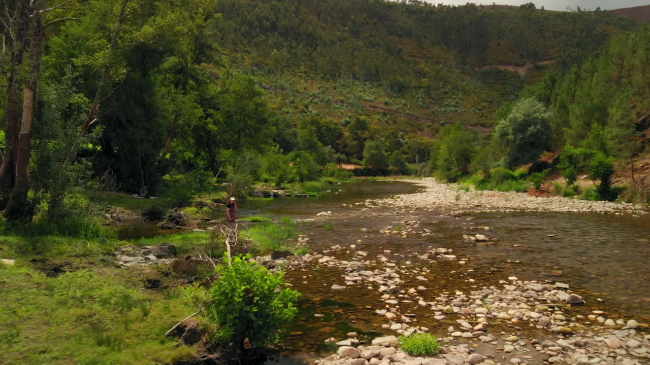 Girl by the River in a Summer Day