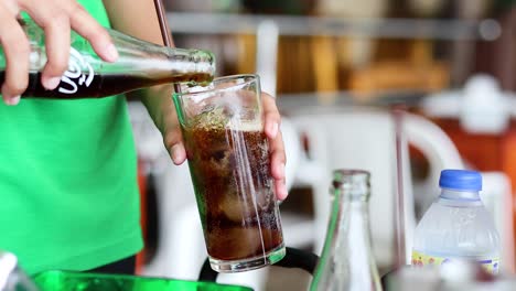 cola refrescante vertida en un vaso con hielo