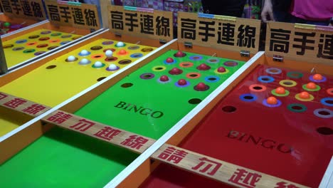 young boy playing traditional bingo game at local taiwanese street night market at douliu city, yunlin county, taiwan