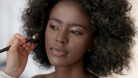 makeup application on a woman with curly hair