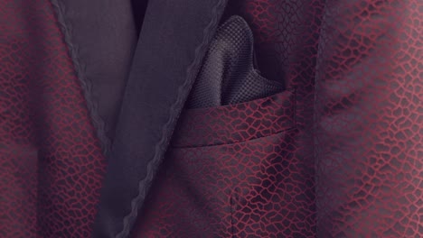 close up of a red textured suit with a black pocket square