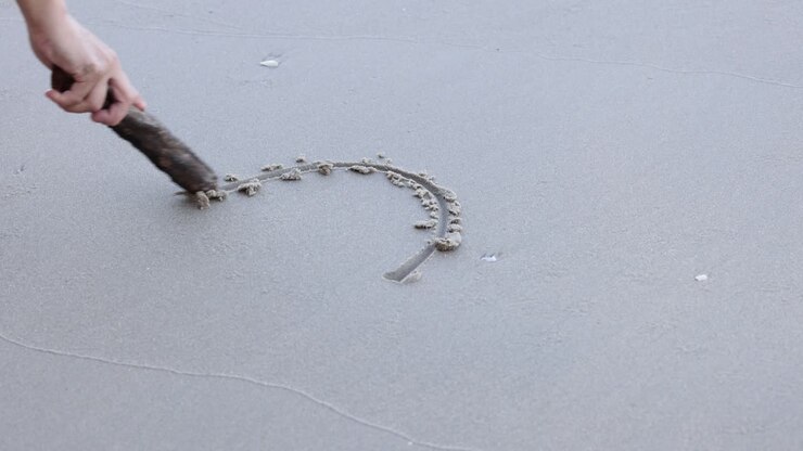 Sequential drawing of a heart shape in sand