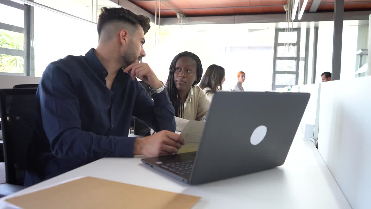 Diverse colleagues working at table in office