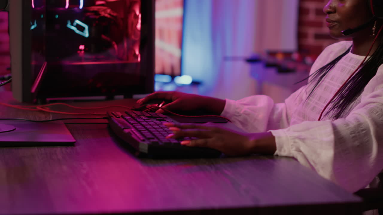 Handheld shot of african american gamer girl streaming while using gaming keyboard