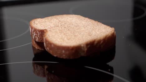 rebanadas de pan apiladas que caen y rebotan en una superficie de cocina negra reflectante