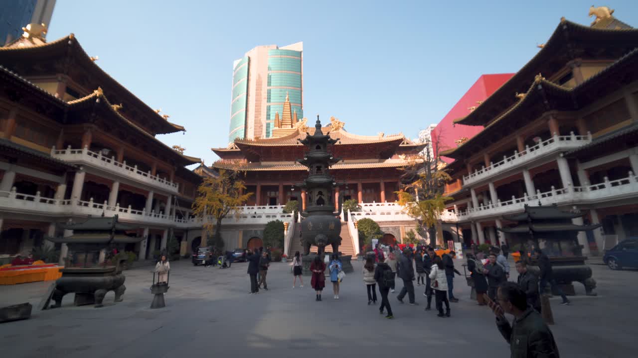 Tourists visiting inside Jing'an Buddhist Temple, a beautiful Chinese religious building in Shanghai, China