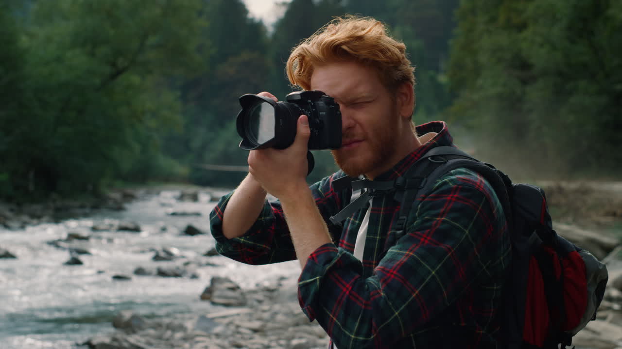 카메라로 사진을 찍는 남자. 카메라 렌즈에서  ⁇ 을 조정하는 사진작가