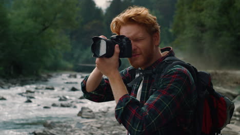 Guy-taking-photos-on-camera.-Photographer-adjusting-zoom-on-camera-lens