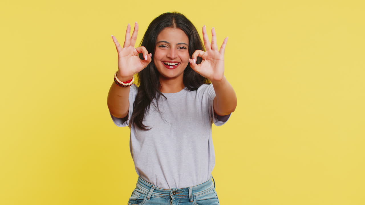 Donna indiana felice che mostra il gesto dell'ok, segno di apprezzamento, feedback positivo, celebra la vittoria, approva un'idea.
