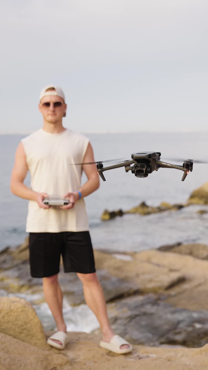 마요르카의 해변 근처에 있는 남성 드론 조종사의 수직 촬영