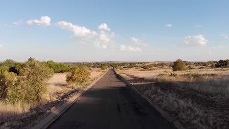 Drone-Retrocediendo-En-Una-Solitaria-Carretera-De-Alquitrán-Sin-Actividad-En-Un-Día-Soleado