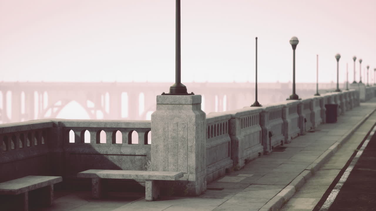 City walkway with benches and streetlights alongside a foggy river