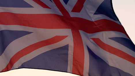 la bandera británica ondeando sobre el cielo al atardecer.