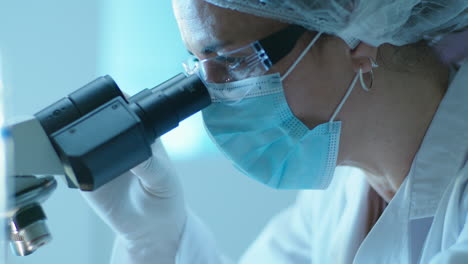 científico usando el microscopio en un laboratorio