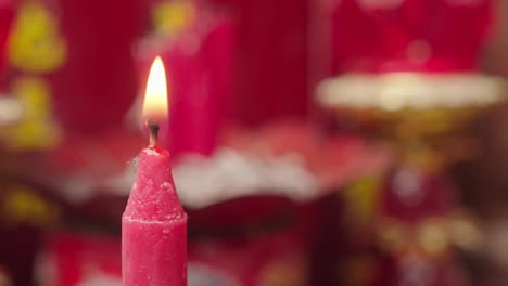 Person-lighting-a-red-candle-with-a-blowtorch