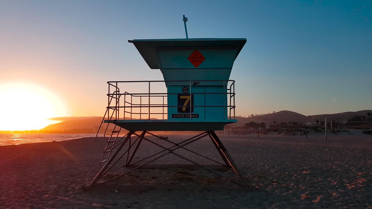 인명 구조원 집 주변의 느린 샷:미국 캘리포니아주 벤추라에 있는 산 부에나벤투라 주립 해변의 일몰 타워