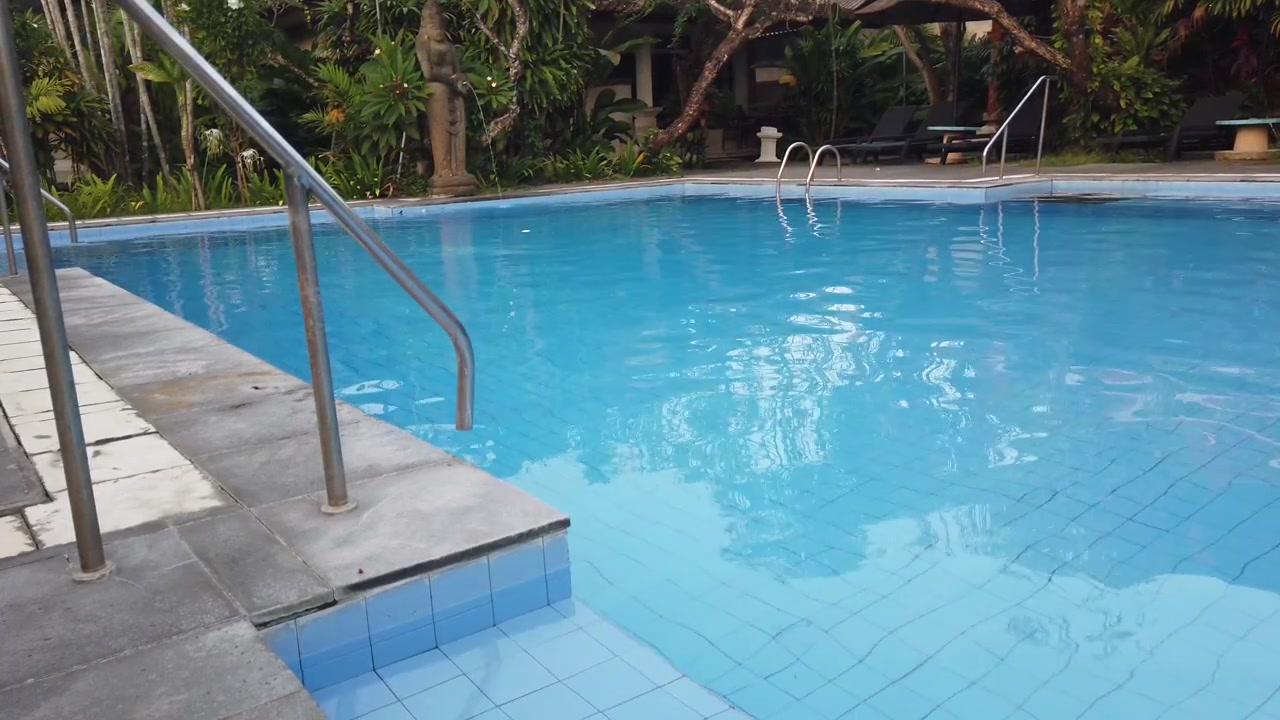 Tropical Resort Swimming Pool with Stone Water Fountain Statue Bali Indonesia