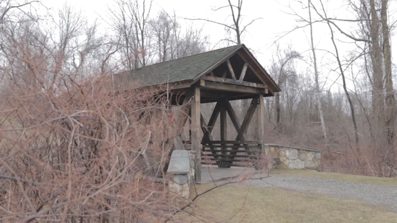 Wooden bridge walk over covering stream.