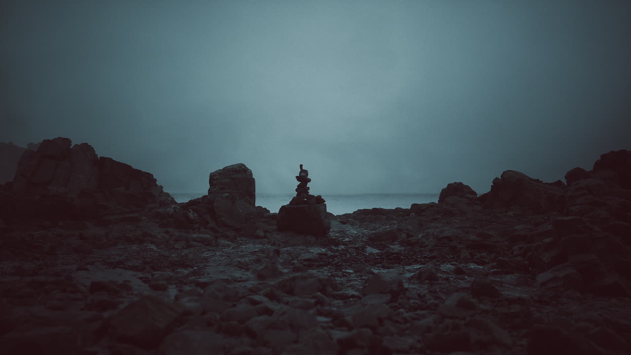Calm seaside evening with rock stack against dark moody backdrop