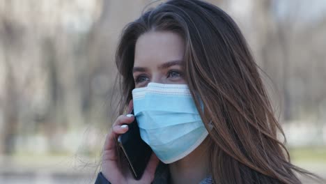 woman wearing mask talking on phone outdoors