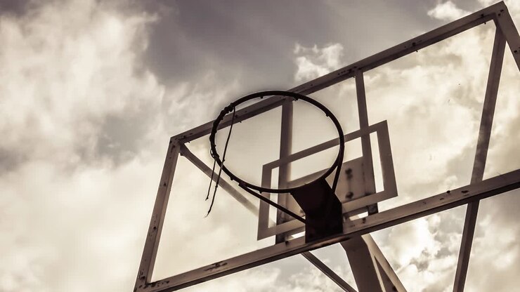 Sfondo di nuvole in movimento drammatico con un canestro da basket dai colori caldi