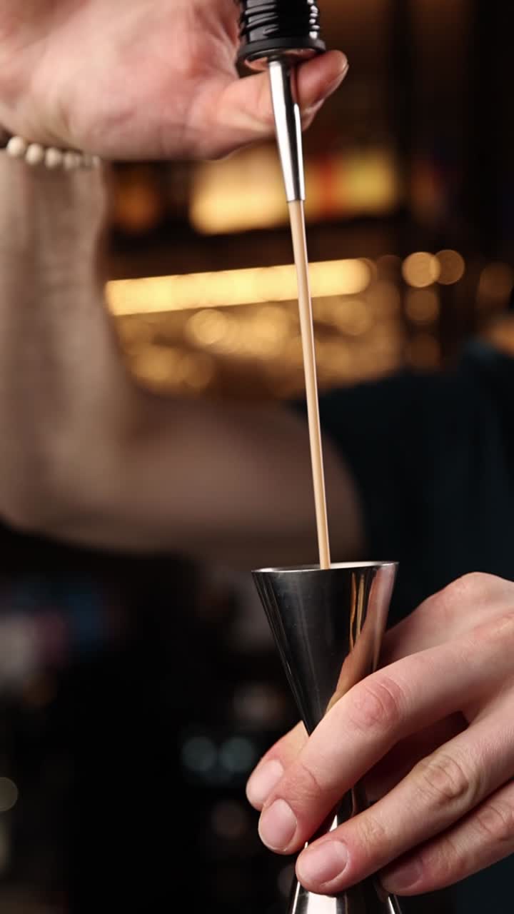Barman versa un cocktail in un misurino