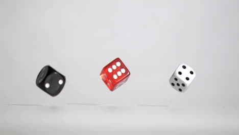 tres dados blancos rojos y negros en una super cámara lenta rebonding