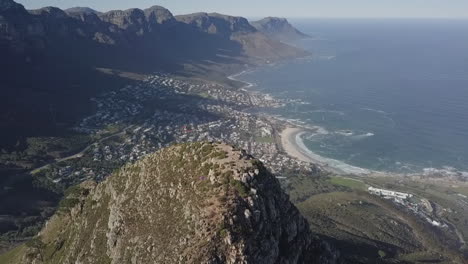 descending aerial reveals tourists on top of lion's head mountain