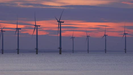 a wind farm generates electricity along a coastline at sunset 3