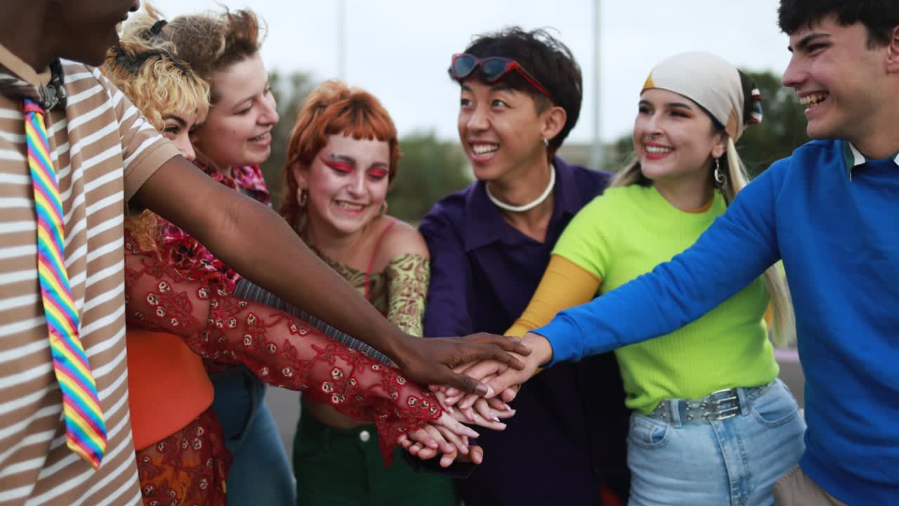 다양한 젊은이들이 함께 축하하고 야외에서 손을 고 있습니다.