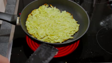 male-cooks-Hasch-Browns-Rösti-Kochen