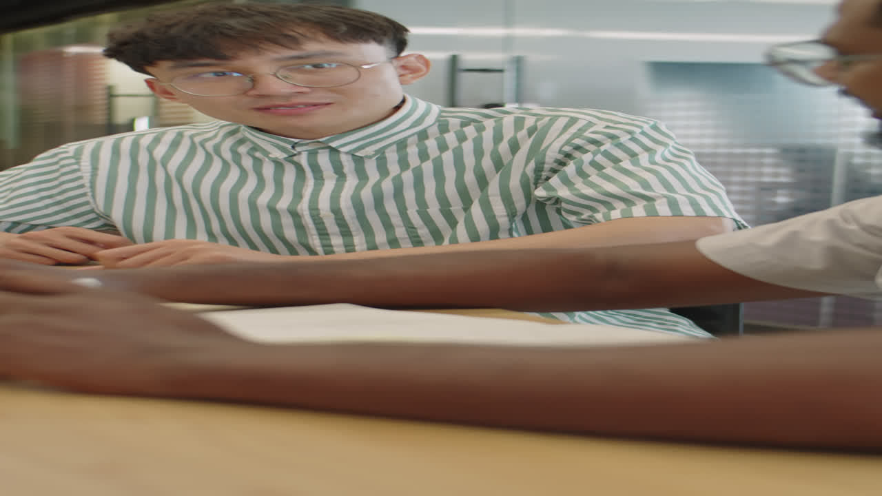 Young Asian Man Discussing Business Project with Colleague