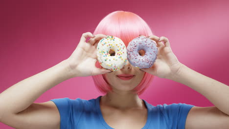 primer plano de una mujer alegre que lleva una peluca rosa y sonríe alegremente