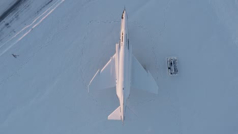 top down aerial of icelandic fighter jet covered in winter snow, keflavik