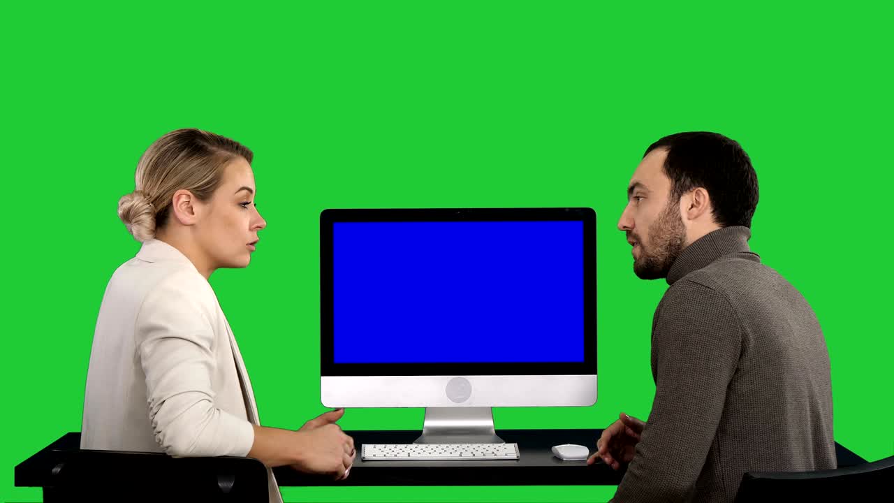 비즈니스 사람들은 컴퓨터 모니터 주변에서 회의를 하고 녹색 화면, 크로마 키, 파란 화면 모 디스플레이에서 화면에 있는 것에 대해 이야기합니다.
